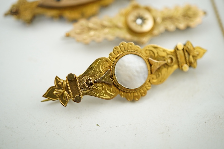 A collection of jewels, comprising: two cross pendants; a heart-shaped locket pendant; a circular locket pendant engraved with a sunflower; a pendant set with a sapphire; a diamond panel brooch; and a sapphire and diamon
